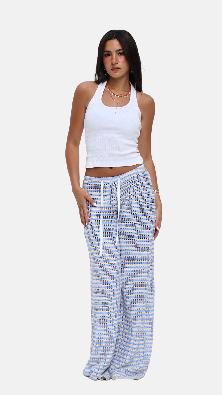 Woman wearing a white tank top and blue checkered pants on a white background