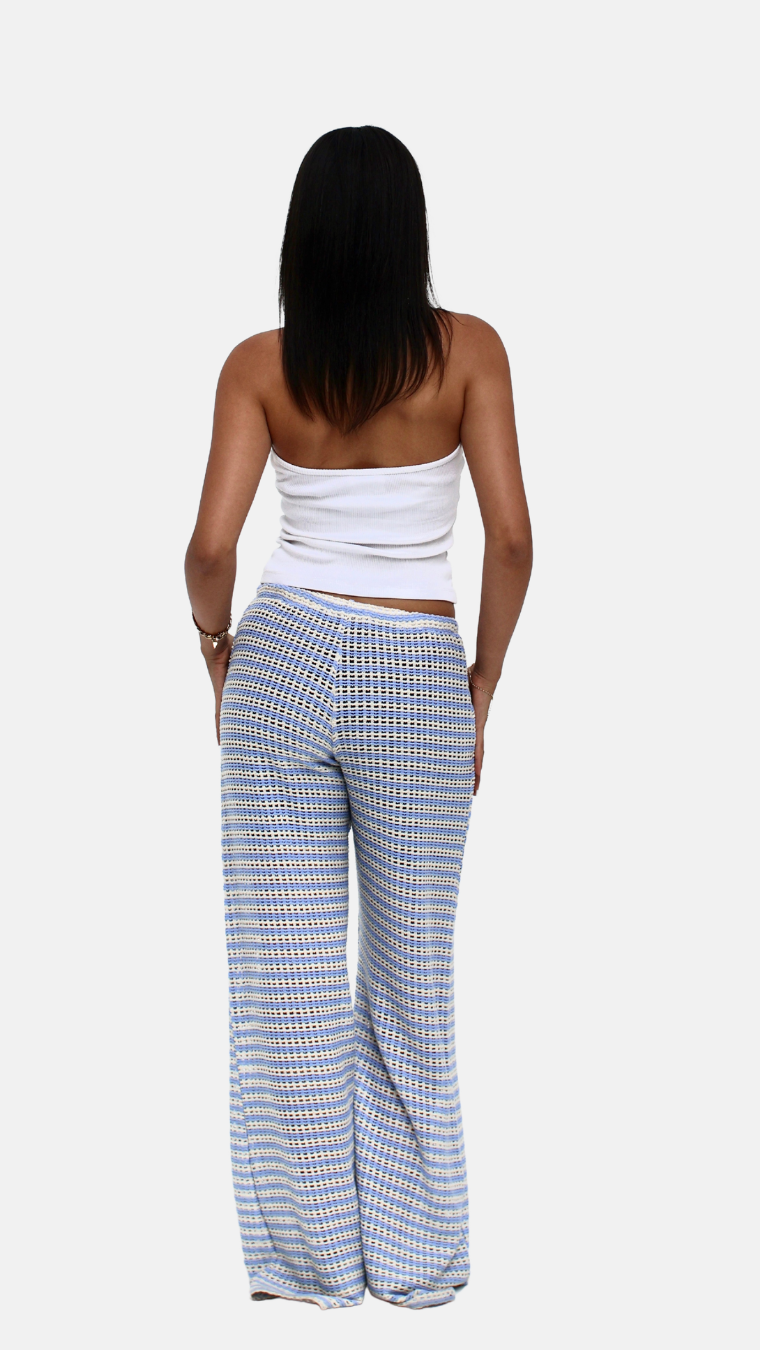 Woman wearing a white top and blue checkered pants on a white background