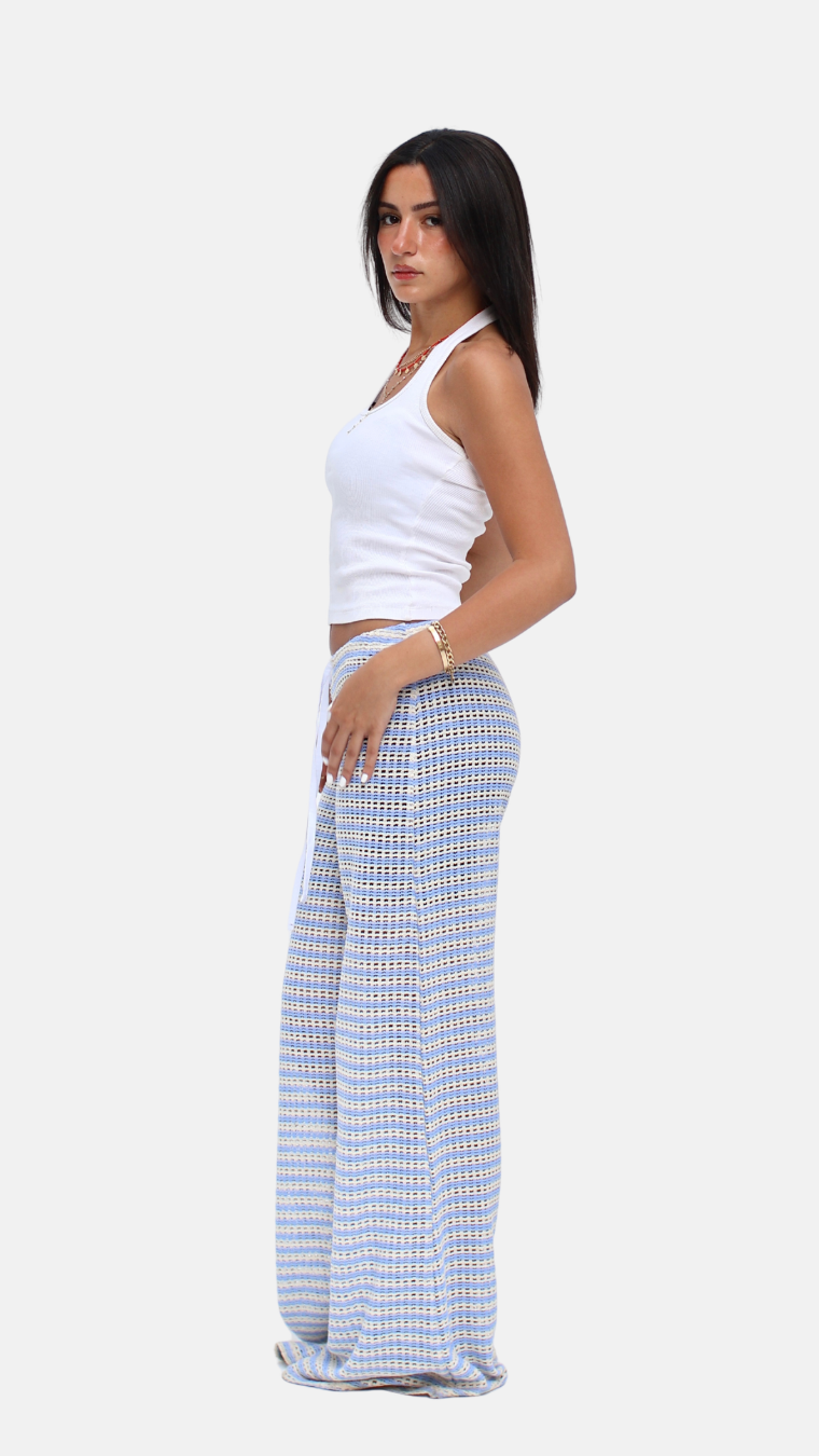 Woman wearing a white top and blue checkered pants on a white background