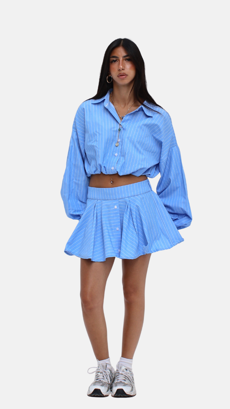 Woman wearing a blue checkered shirt and skirt set on a white background