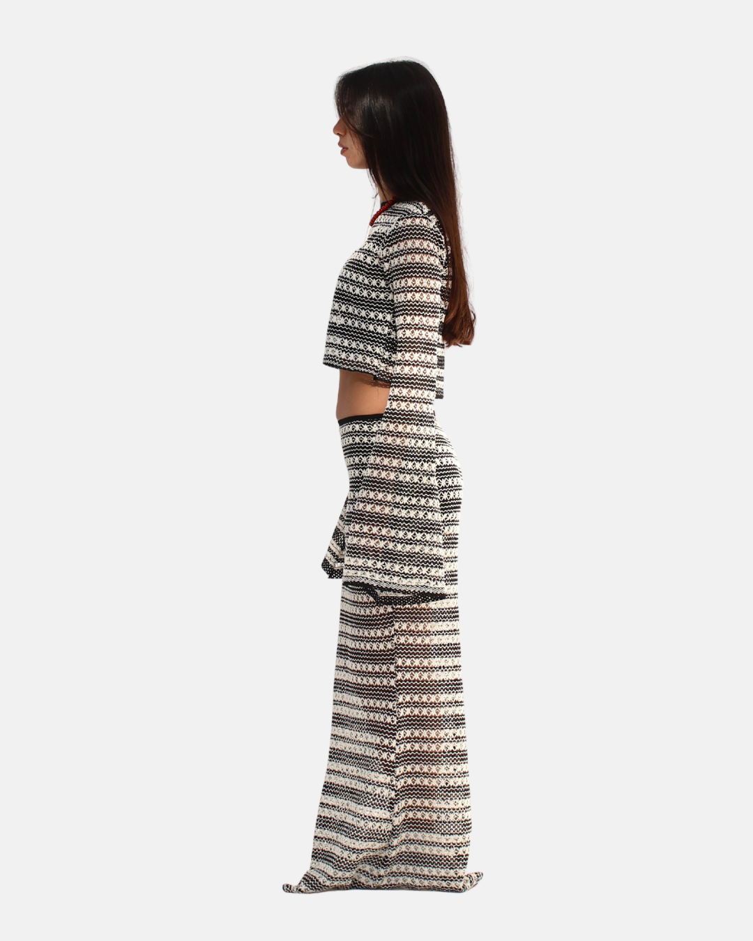 Woman wearing a black and white patterned outfit on a white background