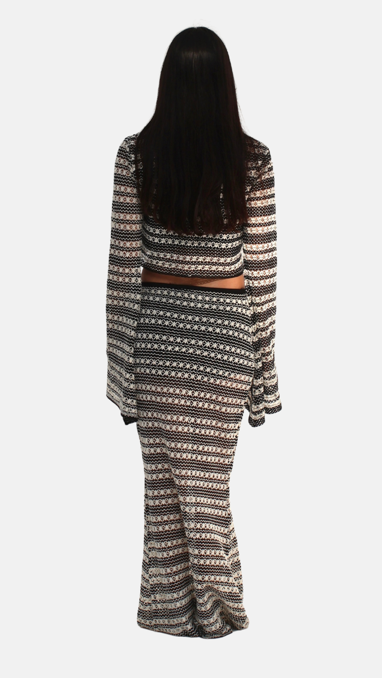 Person wearing a long, patterned dress with a white background